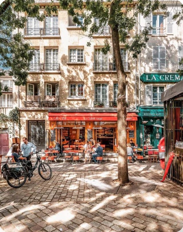 Terrasse de café sur une place pavée et arborée du 20e arrondissement de Paris